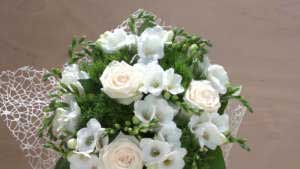 Mazzo di fiori bianco con fresie, roselline e garofano verde